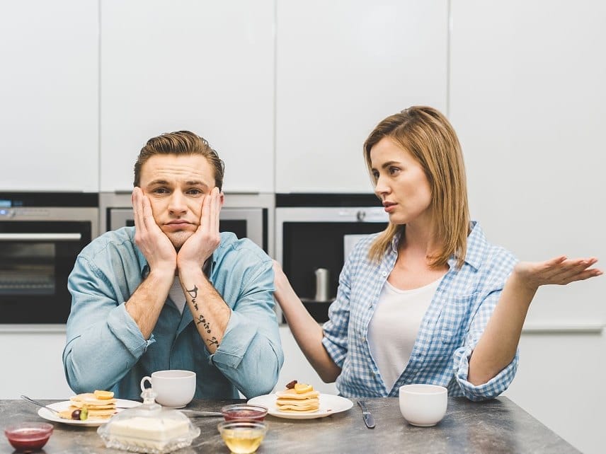 A husband and wife talking together over breakfast, with the wife expressing an apology for her recent behavior in the relationship
